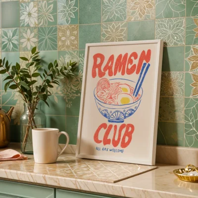 A framed poster that reads 'Ramen Club' with an illustration of a bowl of ramen and chopsticks in a cozy kitchen setting.