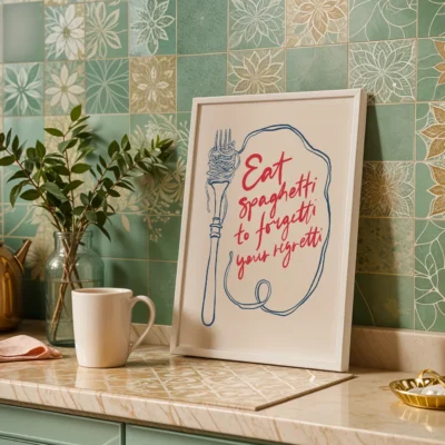 A framed quote about spaghetti in a kitchen setting with green and gold tiled walls.