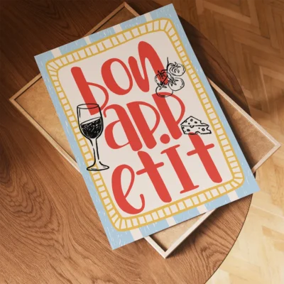 A decorative poster that reads 'Bon Appétit' with illustrations of a wine glass and cheese on a light blue background.