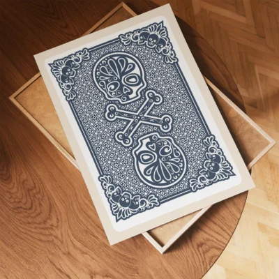 Decorative artwork featuring skulls and crossbones with floral patterns, placed on a wooden table.