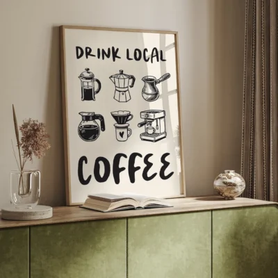 Framed artwork with 'DRINK LOCAL COFFEE' text and coffee brewing illustrations on a neutral wall setting, accompanied by a green cabinet and decorative items.