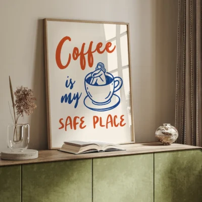 Framed artwork with the text 'Coffee is my SAFE PLACE' alongside a cup of coffee and decorative elements in a cozy interior setting.