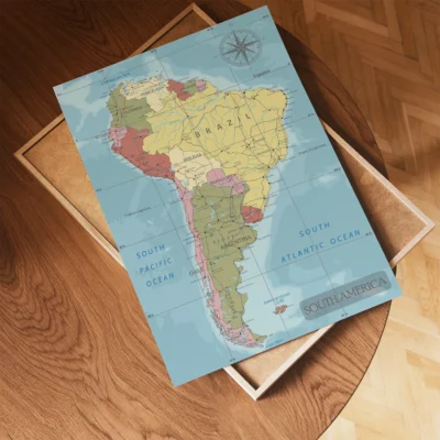 A colorful map of South America displayed on a wooden table, featuring details about countries, oceans, and geographical features.