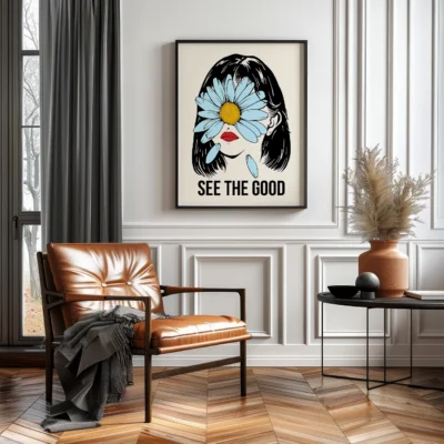 A leather armchair in a living room with a framed artwork of a woman and a flower, and the words 'SEE THE GOOD' on the wall.