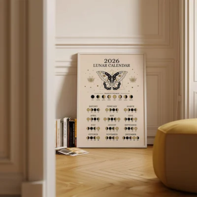2026 celestial calendar framed on wall, showing moon phases and butterfly art in cozy room.