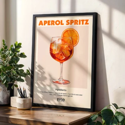 Aperol Spritz cocktail poster in black frame, styled on shelf with plants in modern interior.