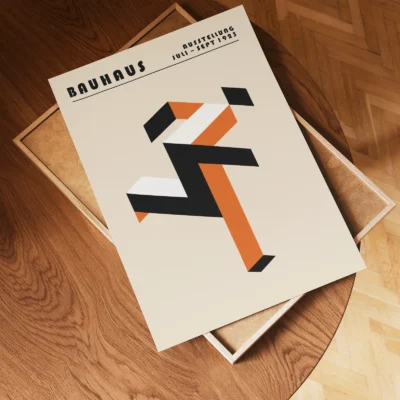 Art print Bauhaus running man poster flat lay on wooden floor, orange geometric Bauhaus composition.