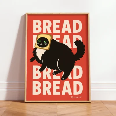 Wood-framed "Bread" cat poster standing on wooden floor