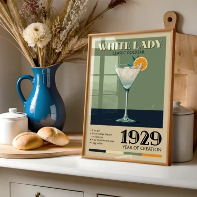 Poster of White Lady classic cocktail recipe in a kitchen setting, with a blue vase and baked goods in the foreground.