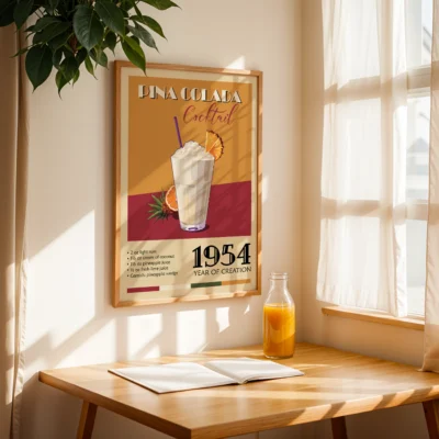Framed poster of Pina Colada cocktail with recipe and year of creation, displayed in a sunlit room.
