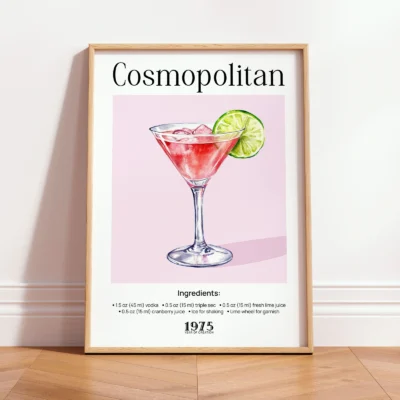 Framed Cosmopolitan vintage cocktail print leaning against wall in a minimalist interior.