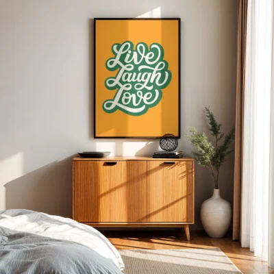 Framed teal “Live Laugh Love” print in natural room setting on wooden cabinet.