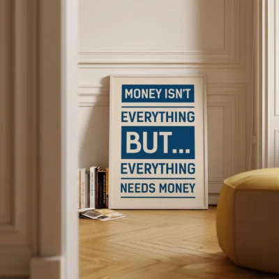 Framed blue motivational money quote print on wooden shelf in cozy interior.