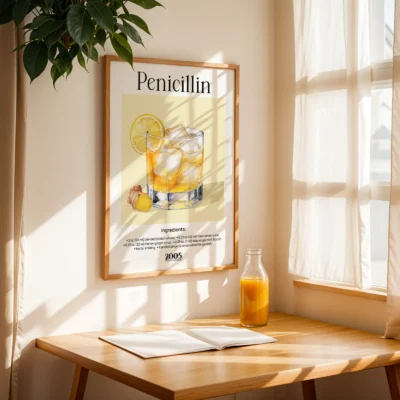 Penicillin cocktail poster on table by window with natural light, vintage whisky bar aesthetic.