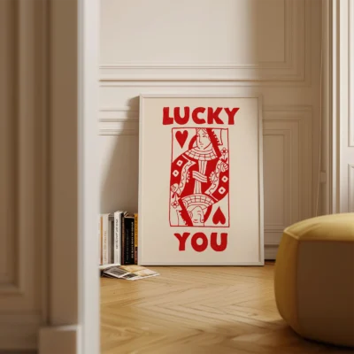 Red and cream Queen of Hearts poster standing on floor in minimalist interior, retro playing card design.