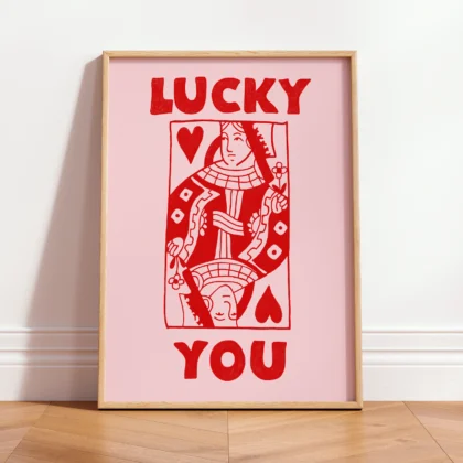 Framed red and pink Queen of Hearts poster leaning against wall, hand-drawn funky retro playing card style.