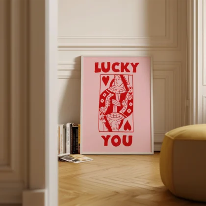 Red and pink Queen of Hearts poster standing on floor in minimalist interior, retro playing card design.