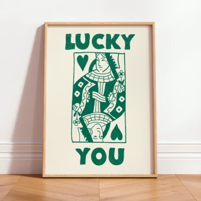 Framed green and cream Queen card poster leaning against wall, hand-drawn retro playing card style.