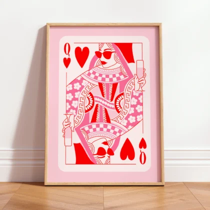 Queen of Hearts playing card art print in pink and red tones, leaning against wall in minimalist interior.