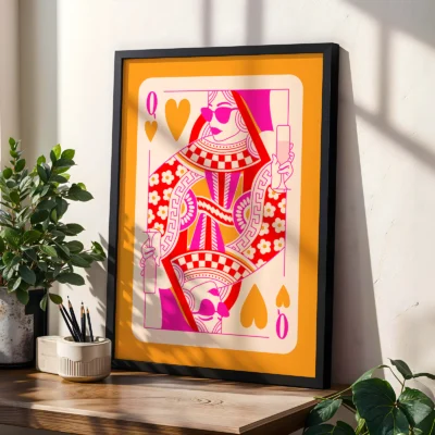 Orange and pink Queen of Hearts poster in black frame, styled on shelf with plants in modern interior.