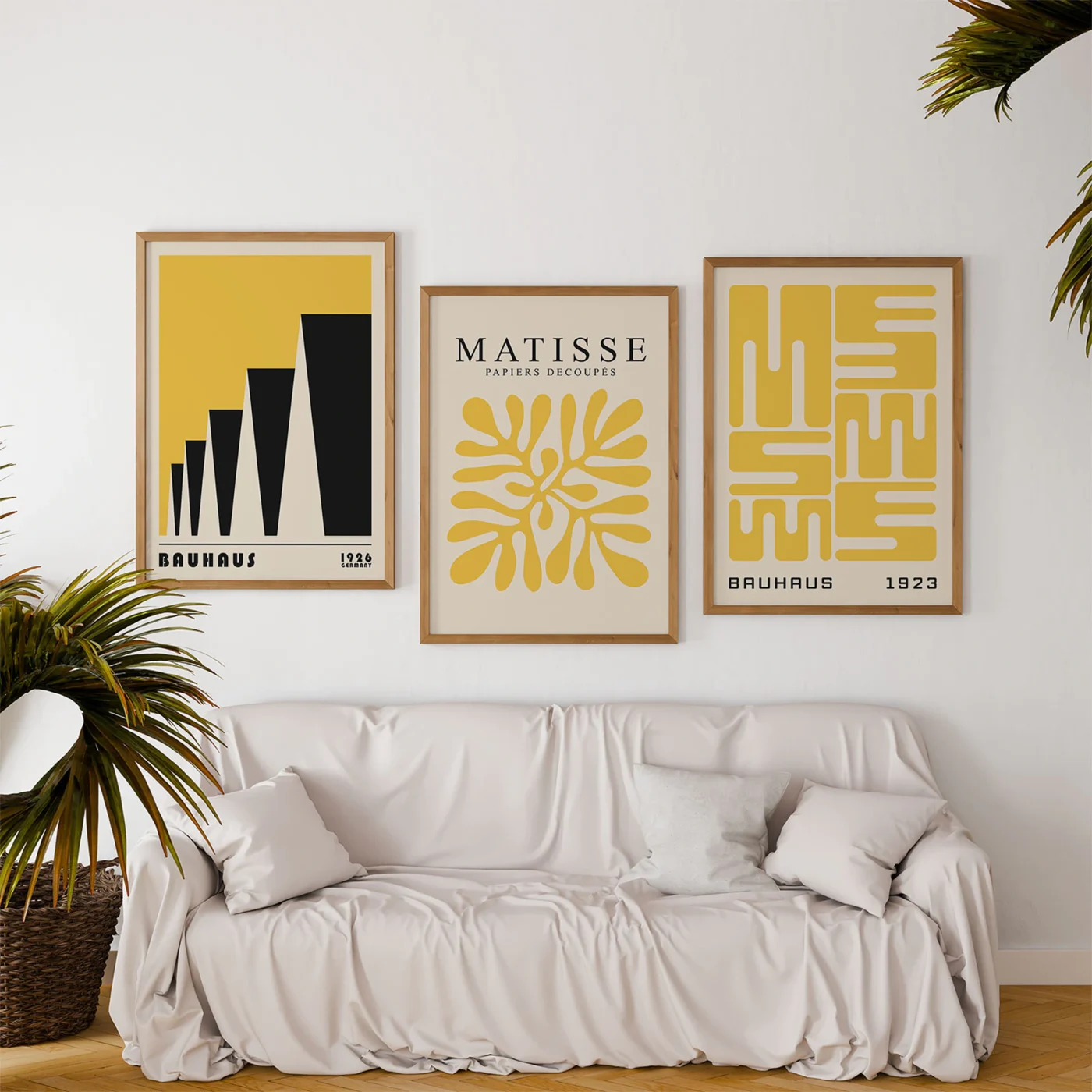 Yellow Bauhaus art prints above soft white sofa with indoor plants