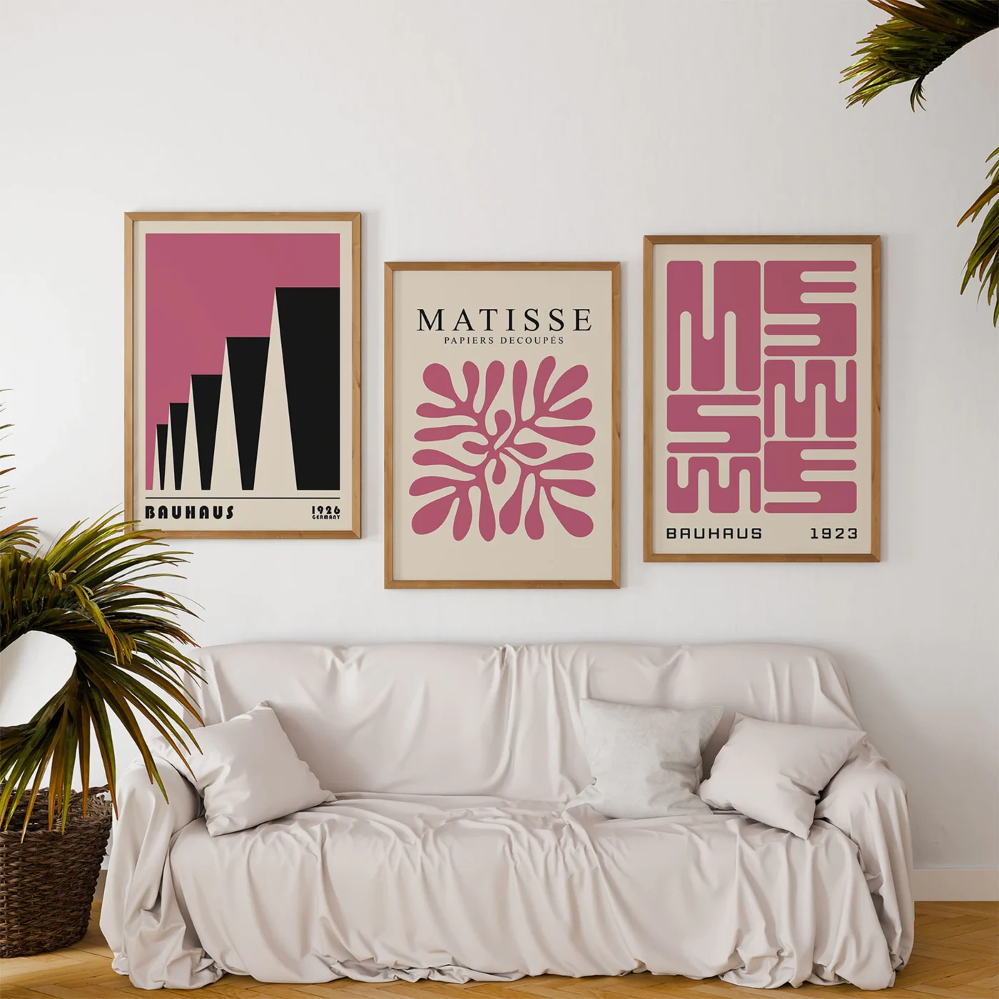 Gallery wall with minimalist pink Bauhaus posters above soft white sofa