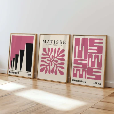 Minimalist Bauhaus prints in pink leaning on white wall in sunlit room