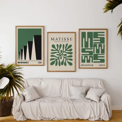 Green and black Bauhaus posters above sofa with plants in living room