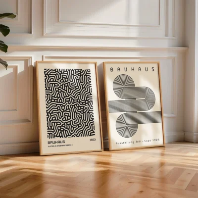 Two Bauhaus posters leaning on floor with wood frame and natural light