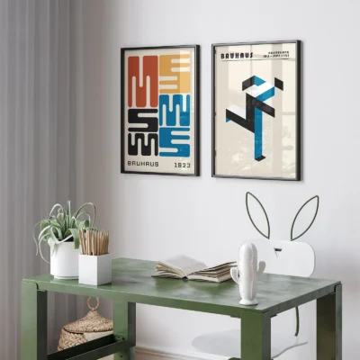 Framed minimalist Bauhaus posters over a desk with green tones