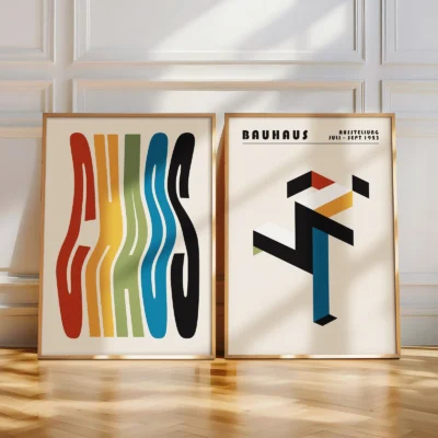 Two colorful Bauhaus posters resting on a light wooden floor
