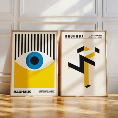 Bauhaus poster set leaning casually against a white wall on a wood floor.