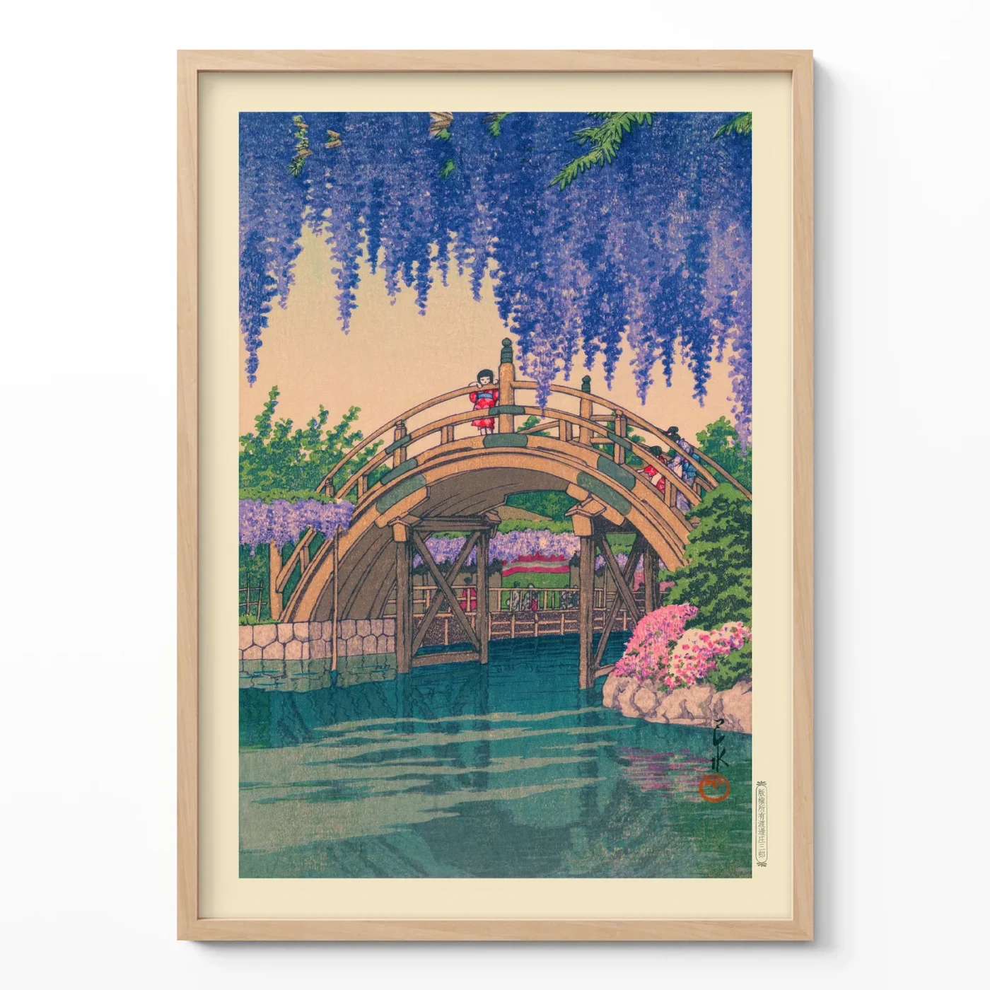 Japanese woodblock print of wisteria flowers and arched bridge over water in frame