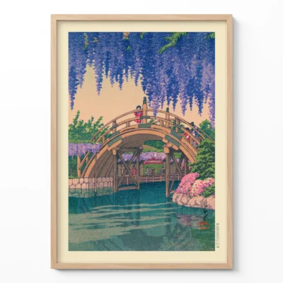 Japanese woodblock print of wisteria flowers and arched bridge over water in frame