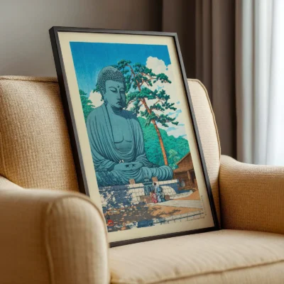 Framed Hasui Buddha print resting on a beige chair